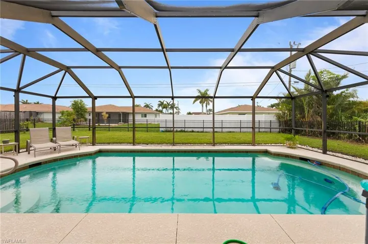 View of swimming pool with glass enclosure, a patio area, and a residential view
