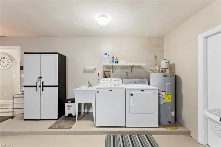 Laundry room with washing machine and dryer and water heater