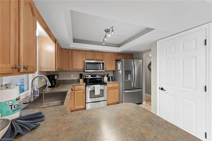 Kitchen featuring appliances with stainless steel finishes and a raised ceiling