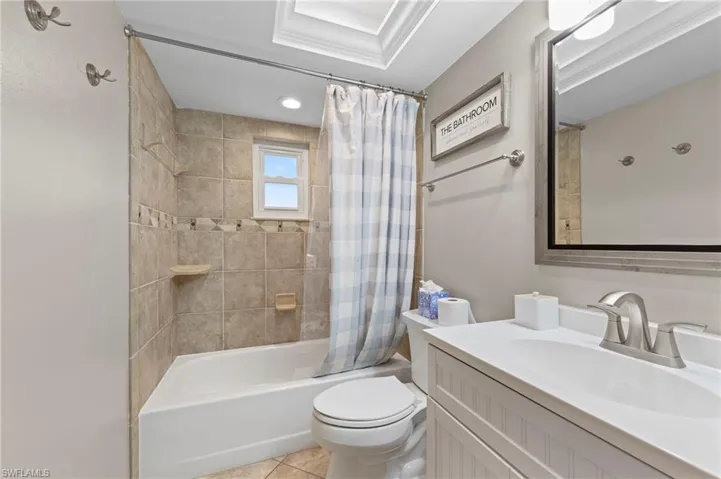 Full bathroom featuring shower / bath combination with curtain, vanity, and tile patterned floors