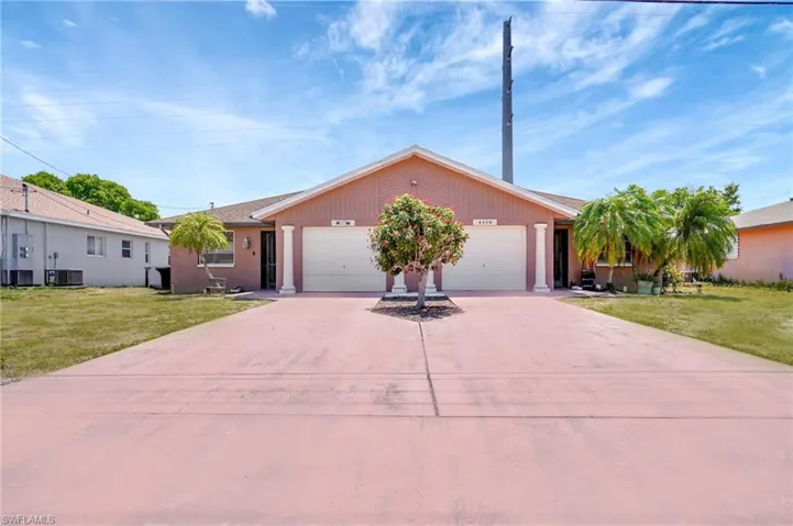 View of front facade featuring a garage and a front yard