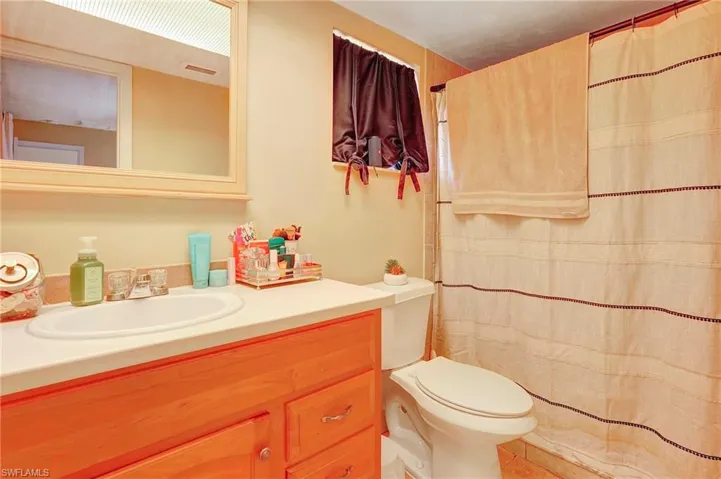 Bathroom with toilet and vanity with extensive cabinet space