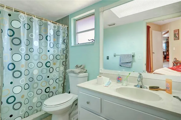 Bathroom featuring large vanity and toilet
