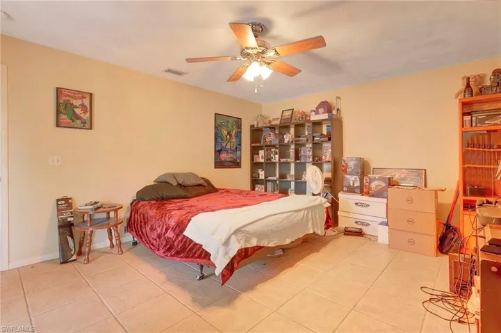 Bedroom with ceiling fan and light tile floors