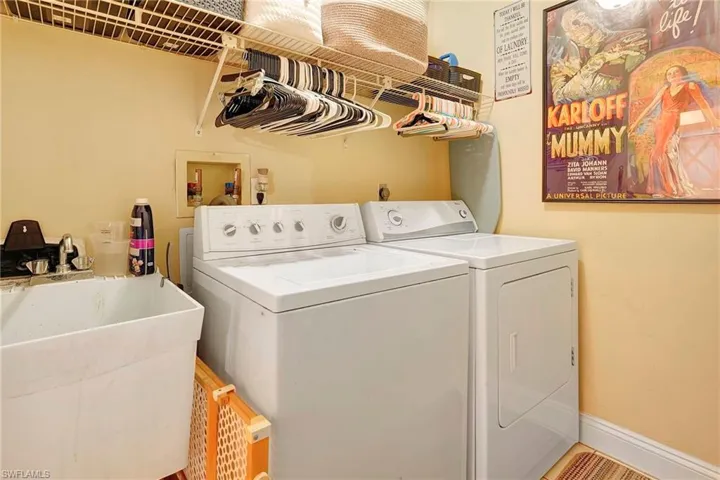Clothes washing area with washer and clothes dryer, sink, washer hookup, and hookup for an electric dryer