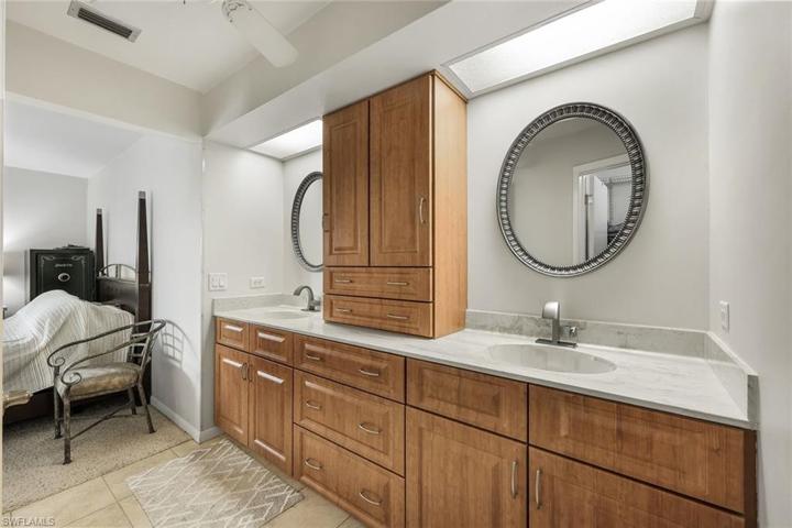 Primary en suite bathroom with nice cabinetry and dual sinks