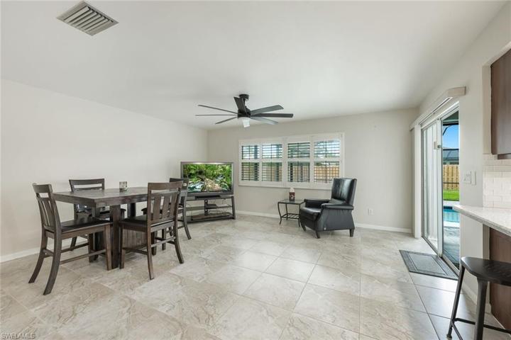 Family and dining room with sliders to pool