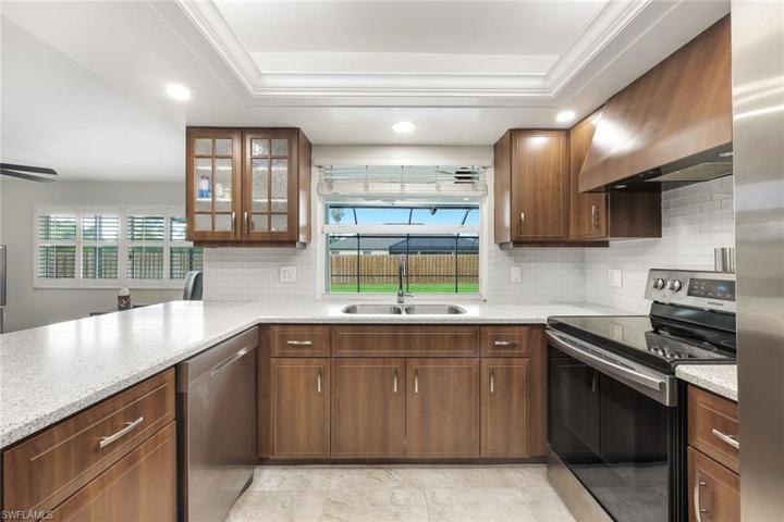 Kitchen with stainless appliances & pass through to pool/lanai