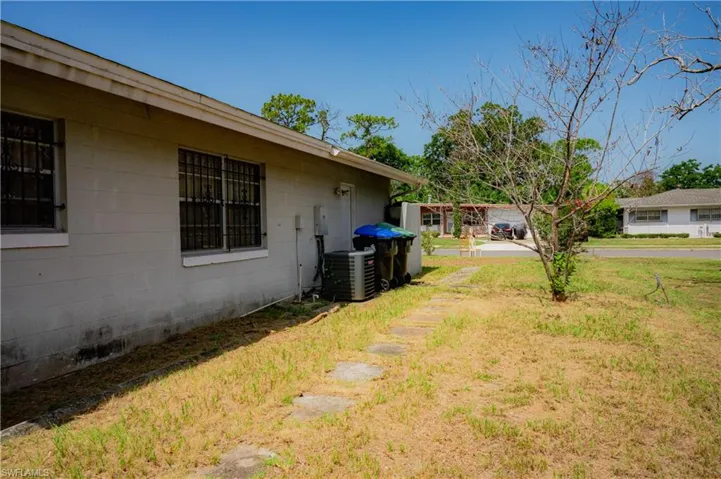 Side yard featuring a concrete block exterior and multiple windows with security bars