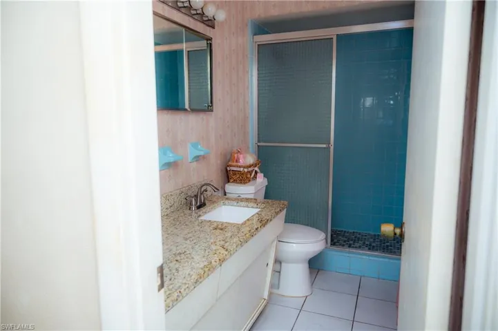 Bathroom featuring a vanity with a granite countertop, undermount sink, and chrome faucet