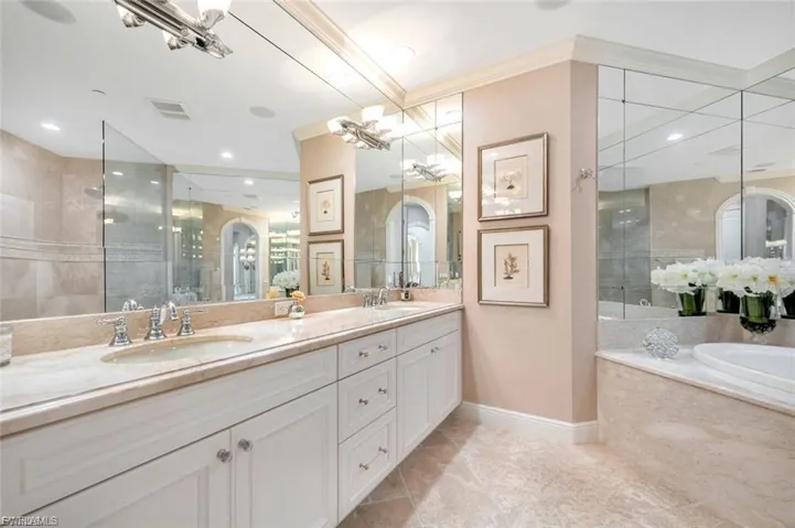 Full bathroom featuring double vanity, a bath, and a walk in shower