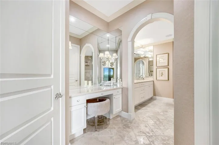 Full bathroom with vanity, crown molding, and stone tile flooring
