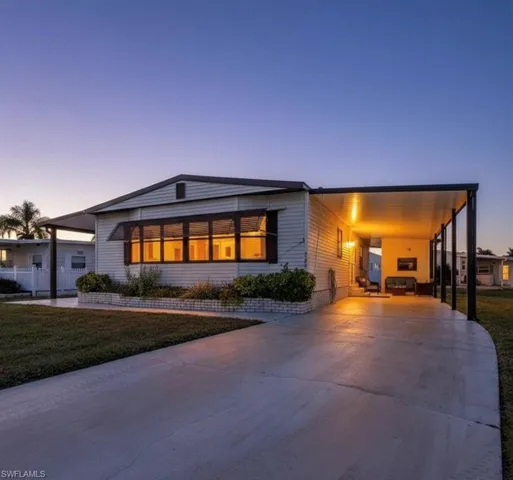 Modern home featuring a carport, driveway, and a yard
