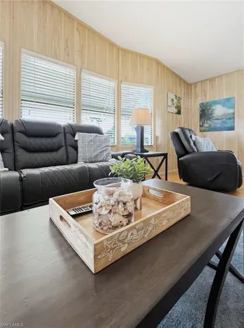 Living room featuring wooden walls and lofted ceiling