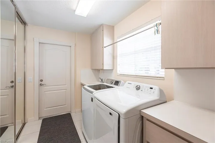 Laundry has sink and a closet and plenty of cabinet storage.