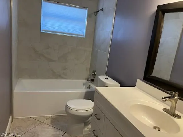 Bathroom featuring vanity, tile patterned floors, toilet, and tub / shower combination
