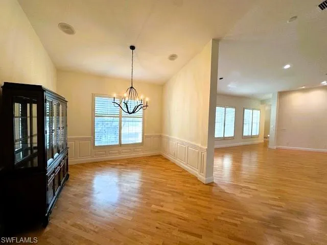Unfurnished dining area with light wood-type flooring, plenty of natural light, and a chandelier