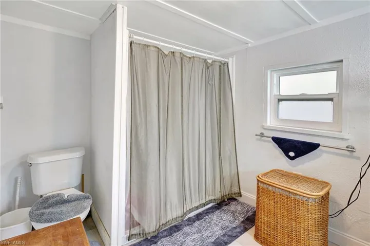 Full bath featuring toilet and a shower with shower curtain