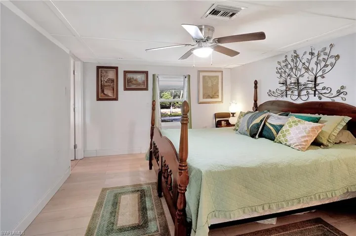 Bedroom with light wood-style flooring, a ceiling fan, and baseboards