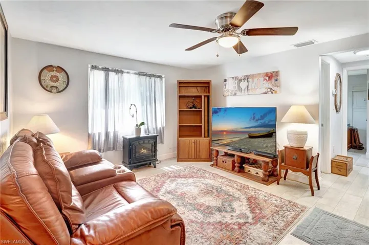 Living room with a wood stove and ceiling fan
