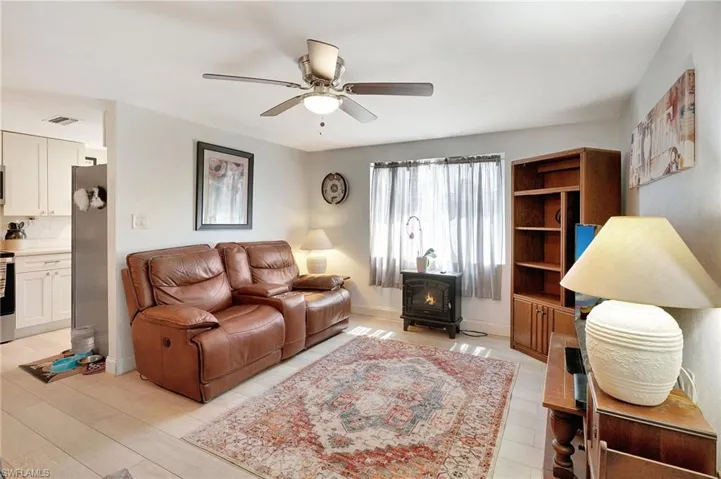Living room with a wood stove and a ceiling fan
