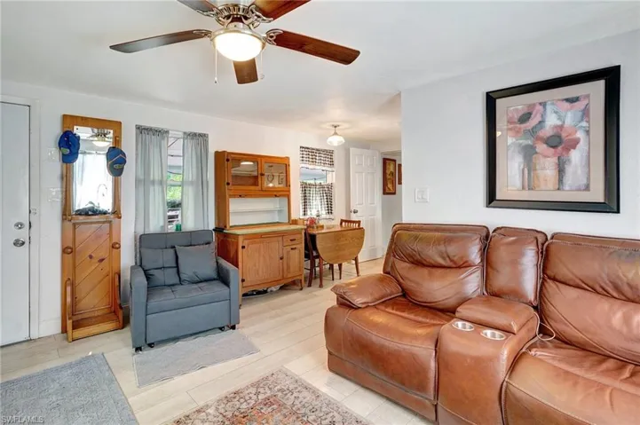 Living area with a ceiling fan and light wood-style floors