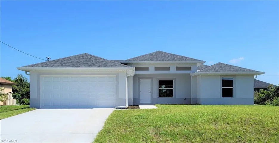 View of front of house featuring a garage and a front lawn