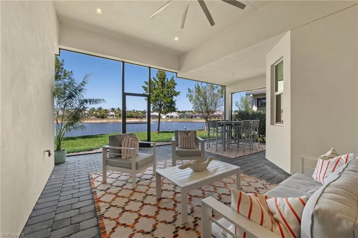 Sunroom featuring a water view, brick floors, and recessed lighting