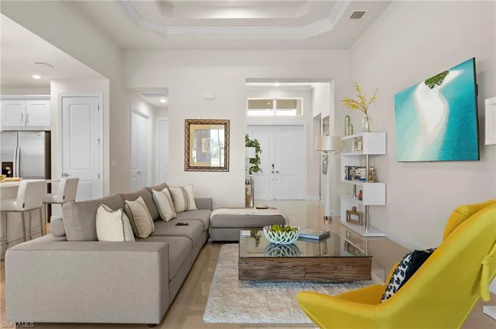 Living area with a raised ceiling and baseboards