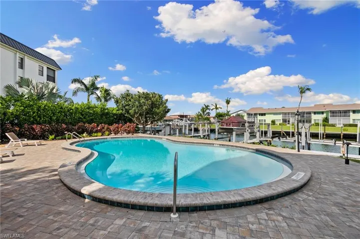 View of swimming pool with a patio and a water view