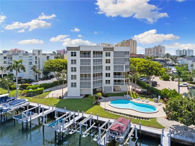 View of property with a water view and a community pool