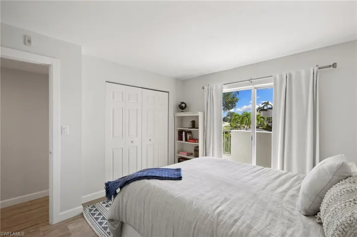 Bedroom featuring wood-type flooring, a closet, and access to exterior