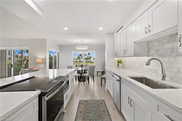 Kitchen featuring appliances with stainless steel finishes, light wood-type flooring, and white cabinetry