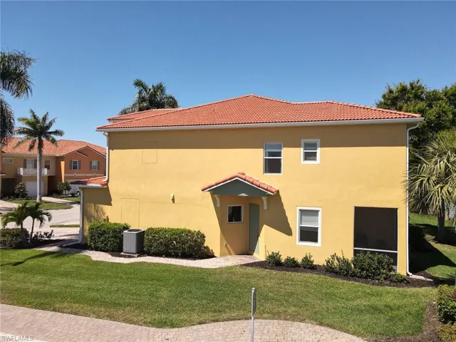 View of home's exterior featuring stucco siding, a tiled roof, and a yard
