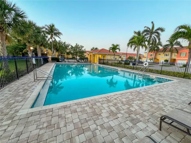Community pool with a residential view, a patio area, and fence