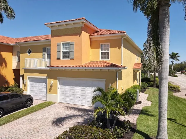 Mediterranean / spanish house featuring a tile roof, a garage, decorative driveway, and stucco siding