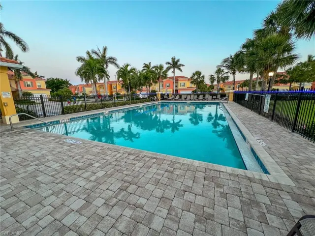 Community pool with a residential view, a patio area, and fence