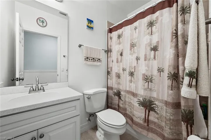 Bathroom with visible vents, toilet, curtained shower, and vanity