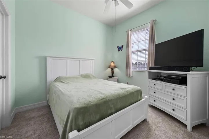 Carpeted bedroom featuring baseboards and a ceiling fan