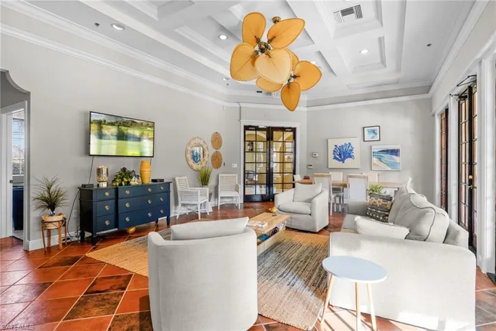 Living room featuring coffered ceiling, ornamental molding, beam ceiling, recessed lighting, and a high ceiling
