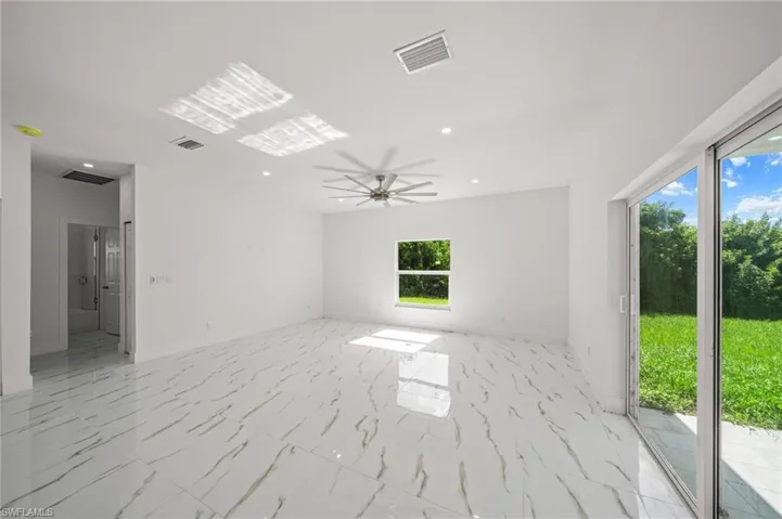 Unfurnished living room featuring recessed lighting, light marble finish floors, and a ceiling fan