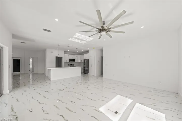 Kitchen featuring appliances with stainless steel finishes, pendant lighting, a center island with sink, white cabinetry, and recessed lighting