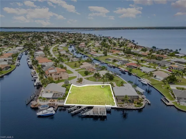 Aerial perspective of suburban area with a large body of water and property boundaries highlighted