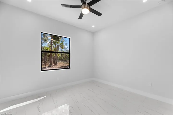 Empty room with marble finish floor, ceiling fan, baseboards, and recessed lighting