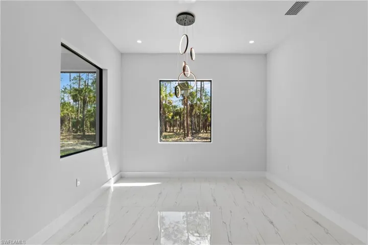 Empty room with marble finish floor, baseboards, visible vents, and recessed lighting