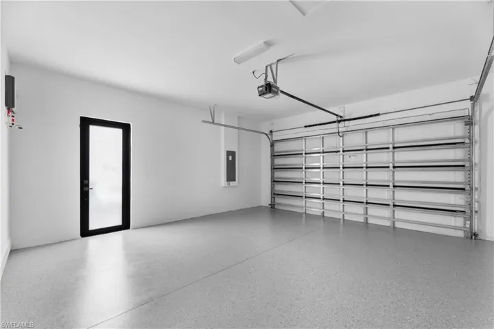 Garage featuring electric panel and a garage door opener