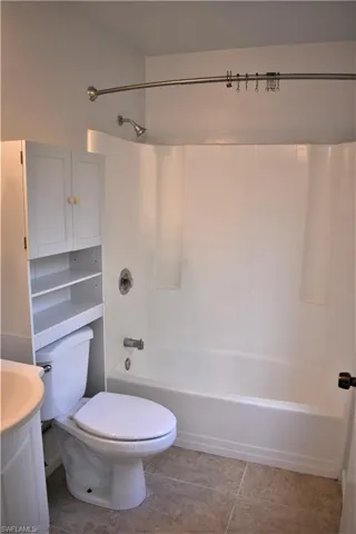 Full bathroom with toilet, vanity, shower / bathing tub combination, and tile patterned flooring