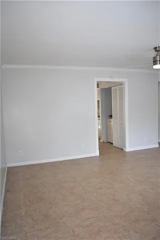 Spare room featuring ornamental molding, washer / dryer, and baseboards