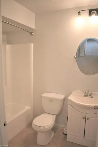 Full bathroom featuring baseboards, toilet, tile patterned floors, vanity, and shower / tub combination