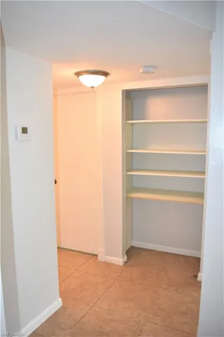 Corridor featuring baseboards and tile patterned flooring